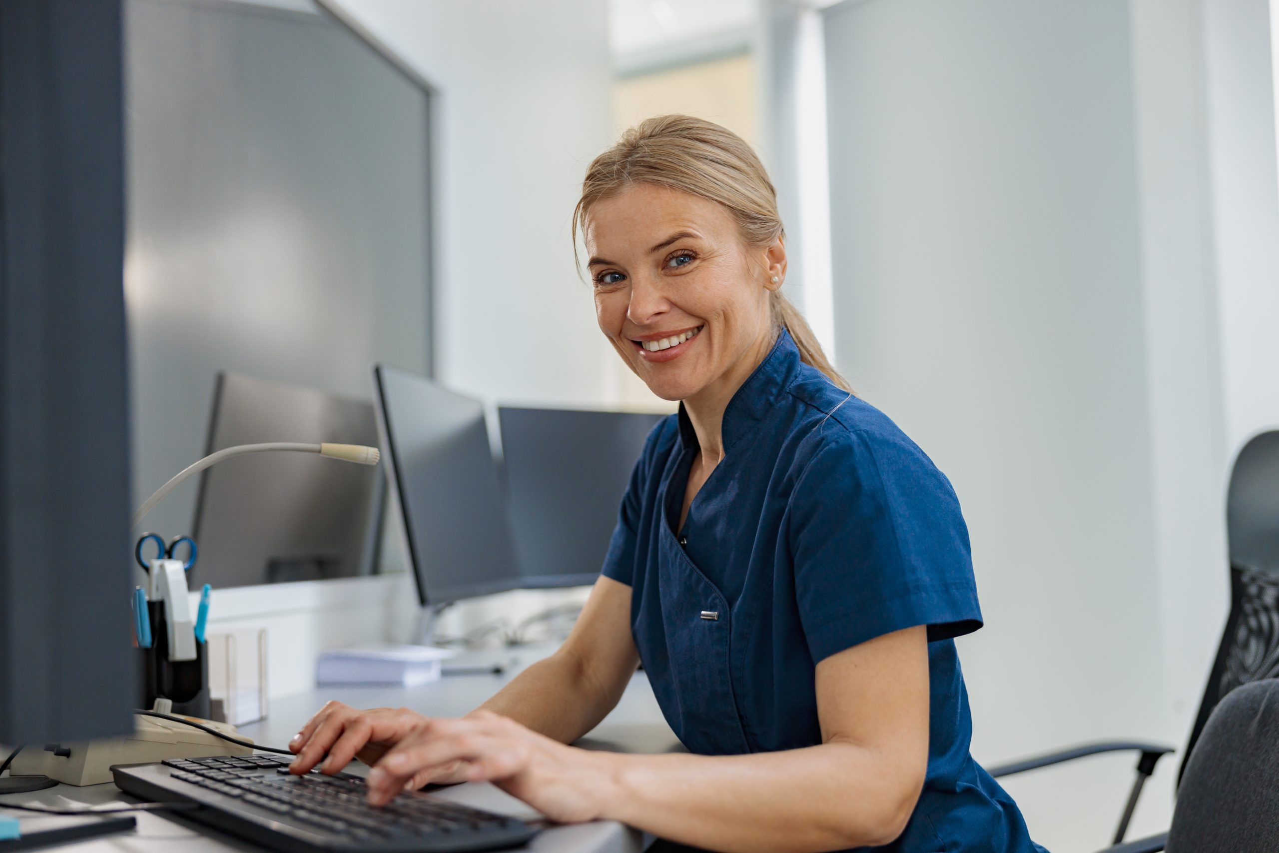 Nurse,On,Duty,Working,On,Computer,At,The,Reception,Desk