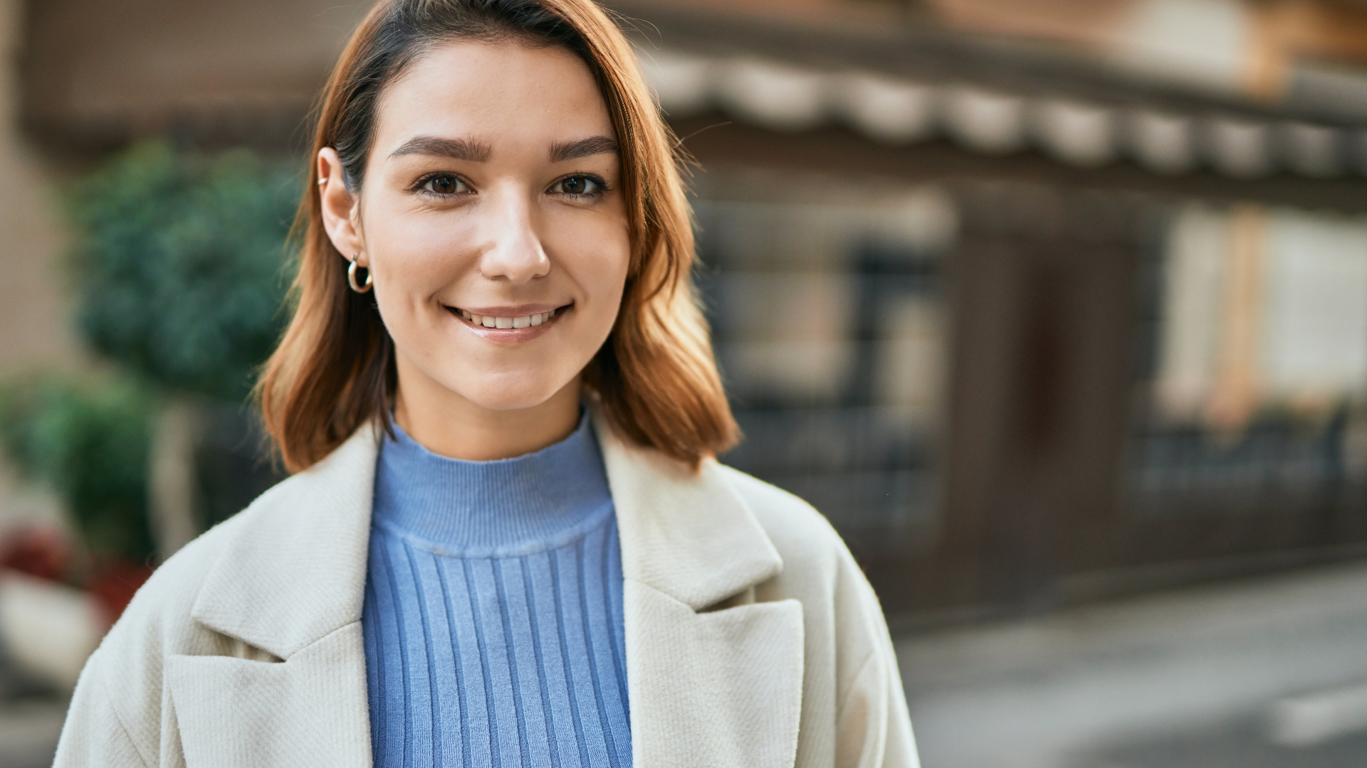 Femme souriante portant manteau bleu et beige